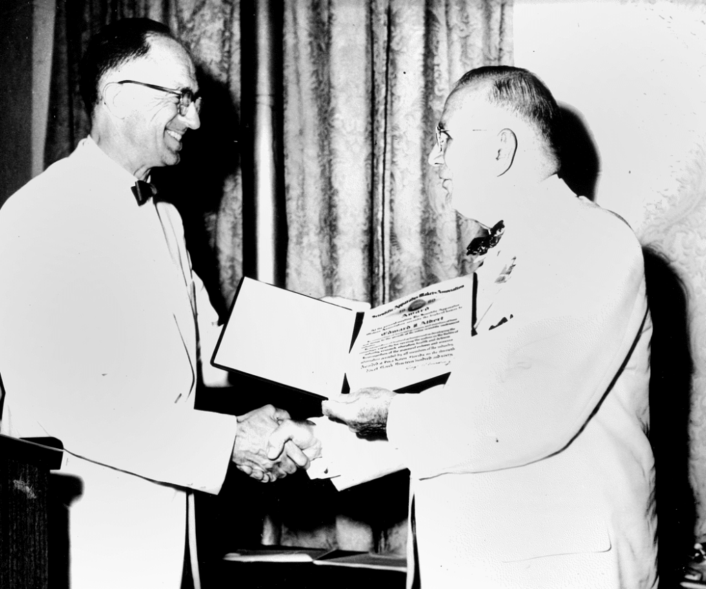 Photo of Edward J. Albert accepting an industry award.